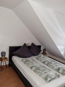 Bett mit weißer Bettwäsche und lila Kissen in der Unterkunft Sternenhimmel-AW in Bad Neuenahr-Ahrweiler
