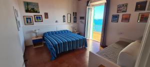 una camera con un letto con una coperta a righe blu di Villa Le Sprizze a bordo del mare - Goelba a Marciana Marina
