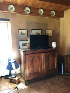 a television on a wooden cabinet in a room at Détente en campagne dans le quercy une Chambre lit double et un matelas d appoint une personne dans le salon in Castelnau-de-Montratier