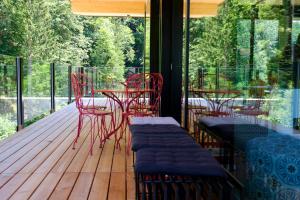 a porch with red chairs and tables on a deck at Oberstdorf Hostel in Oberstdorf