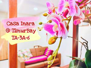 クアンタンにあるTimurBay Seafront Residence at Casa Inaraのソファ付きの部屋のピンクの花