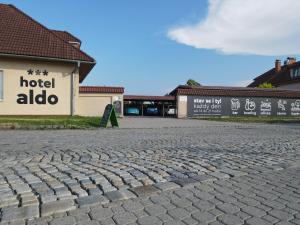 Uničov的住宿－Hotel Aldo，一条鹅卵石街道,位于酒店前方