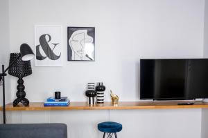 a living room with a television on a wooden shelf at Kaleo Chios Luxury Apartments in Chios