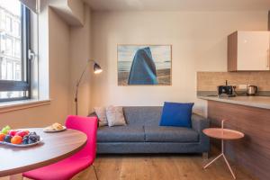 a living room with a couch and a table at PREMIER SUITES PLUS Glasgow Bath Street in Glasgow