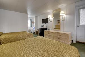 a hotel room with two beds and a mirror at Empress Motel in Ocean City