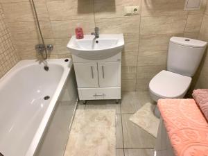a bathroom with a sink and a tub and a toilet at Комфортна квартира. Поруч парк in Ternopilʼ +6 photos