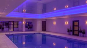 a swimming pool in a house with purple lighting at The Woolacombe Bay Hotel in Woolacombe