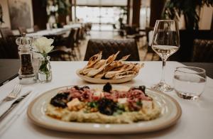 a table with a plate of food and a glass of wine at The Woolacombe Bay Hotel in Woolacombe