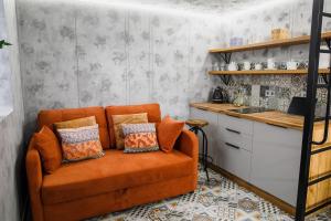 un soggiorno con divano arancione e cuscini di Apart 1 Chernivtsy a Černivci