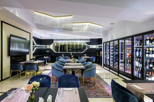 a restaurant with blue chairs and tables and a wine cellar at Epoque Hotel - Relais & Chateaux in Bucharest