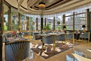 a restaurant with tables and chairs and large windows at Epoque Hotel - Relais & Chateaux in Bucharest