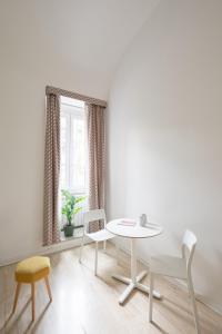 a white table and chairs in a room with a window at Trevi Fountain Guesthouse in Rome