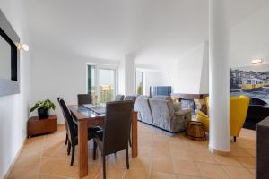 uma sala de estar com uma mesa e um sofá em VILASOL - Captain's wonderful retreat for 4 with AC facing the gardens em Quarteira