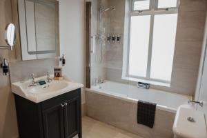 a bathroom with a sink and a bath tub and a window at The Woolacombe Bay Hotel in Woolacombe