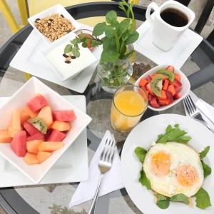 a table topped with plates of fruit and eggs at Kaleo Hotel Boutique in San Salvador