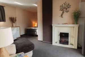 a living room with a fireplace and a bed at Ferienhaus LORINI in Kolkwitz