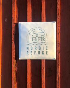 a sign for a nordic refuge on a wooden fence at Nordic Refuge B&B in Fröskog