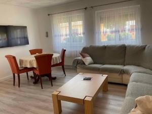 ein Wohnzimmer mit einem Sofa und einem Tisch in der Unterkunft Apartment Balatonbereny 2 in Balatonberény