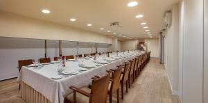 a long dining room with a long table and chairs at Melia Plaza Valencia in Valencia