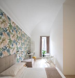 ローマにあるトレビ ファウンテン ゲストハウスのベッドルーム1室(トロピカルな壁紙のベッド1台付)