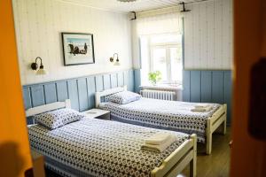 two beds in a room with blue walls at Vanatoa Taluhotell in Koguva
