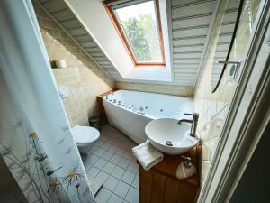 a bathroom with a tub and a sink and a toilet at Vanatoa Taluhotell in Koguva