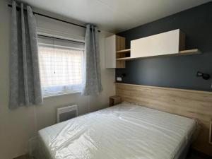 a small bedroom with a bed and a window at Superbe Mobil home 6-8 personnes (57) in Saint-Jean-de-Monts