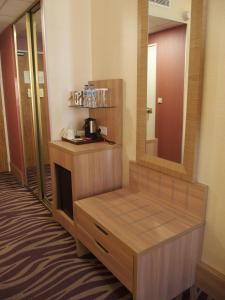 a hotel room with a vanity with a mirror at Plaza Hotel Capitole Toulouse - Anciennement-formerly CROWNE PLAZA in Toulouse