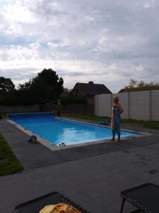 una mujer parada frente a una piscina en Vivere en Houthalen