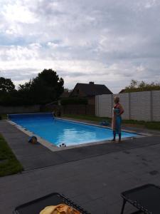 a woman standing in front of a swimming pool at Vivere in Aan de Wolfsberg