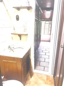 a small bathroom with a sink and a hallway at Pousada Praia do Recreio in Rio de Janeiro