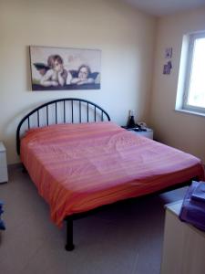 a bedroom with a bed with an orange blanket on it at Appartamento Ognina Siracusa in Ognina