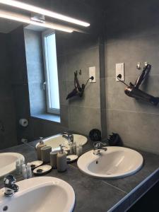 La salle de bains est pourvue de 3 lavabos et d'un grand miroir. dans l'établissement Bocskai Domb Vendégház, à Nagykálló