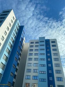 dois edifícios altos com o céu ao fundo em Blue Tower Apartments em Suceava