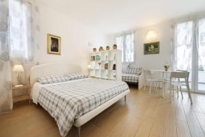 a white bedroom with a bed and a table and chairs at B&B Cá Bianca Ventisette Riccione in Riccione