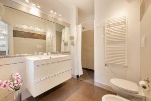 bagno con lavandino, servizi igienici e specchio di B&B Cá Bianca Ventisette Riccione a Riccione