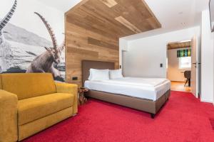- une chambre avec un lit et un canapé dans l'établissement lechner living apartments, à Wald im Pinzgau