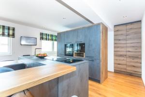 a kitchen with wooden cabinets and a counter top at lechner living apartments in Wald im Pinzgau