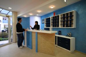 two people standing at a counter in a room at Hotel Bella Vista in Budva