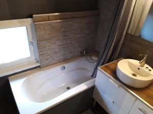 a small bathroom with a tub and a sink at Le Héron ( Gîte ) in Blaimont