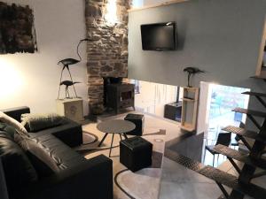 a living room with a couch and a tv on the wall at Le Héron ( Gîte ) in Blaimont