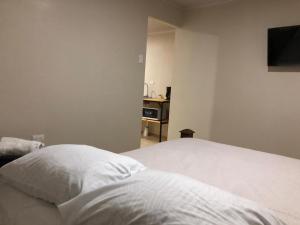 Rivera Family Apartments في Santiago Este: غرفة نوم بسرير ابيض وتلفزيون