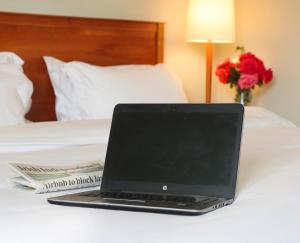 a laptop computer sitting on top of a bed at Ballymascanlon Hotel and Golf Resort in Dundalk