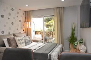 a bedroom with a bed and a couch and a window at Apartamento Sofia in Pineda de Mar