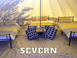 un groupe de lits dans une tente avec les mots sept dans l'établissement Rivers View Holidays, à Westbury on Severn