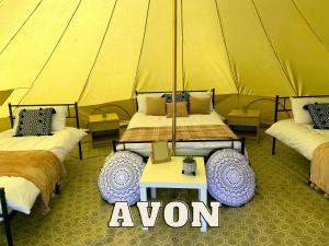 um quarto com três camas numa tenda em Rivers View Holidays em Westbury on Severn