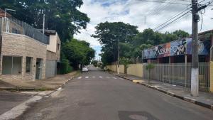 an empty street with a building and a fence at Espaço coração de mãe in Pirapòzinho