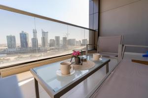 uma mesa com duas xícaras na frente de uma janela em White Sage - Elite Residence 1 bedroom em Dubai