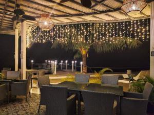 un restaurante con mesas, sillas y luces en la pared en Down South 118 Beach Resort, en Oslob