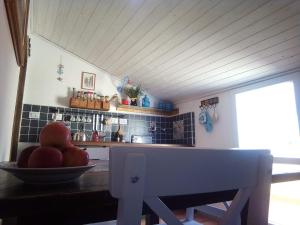 eine Küche mit einer Schale Äpfel auf dem Tisch in der Unterkunft Piccola Casa Di Sardegna in Villanova Monteleone